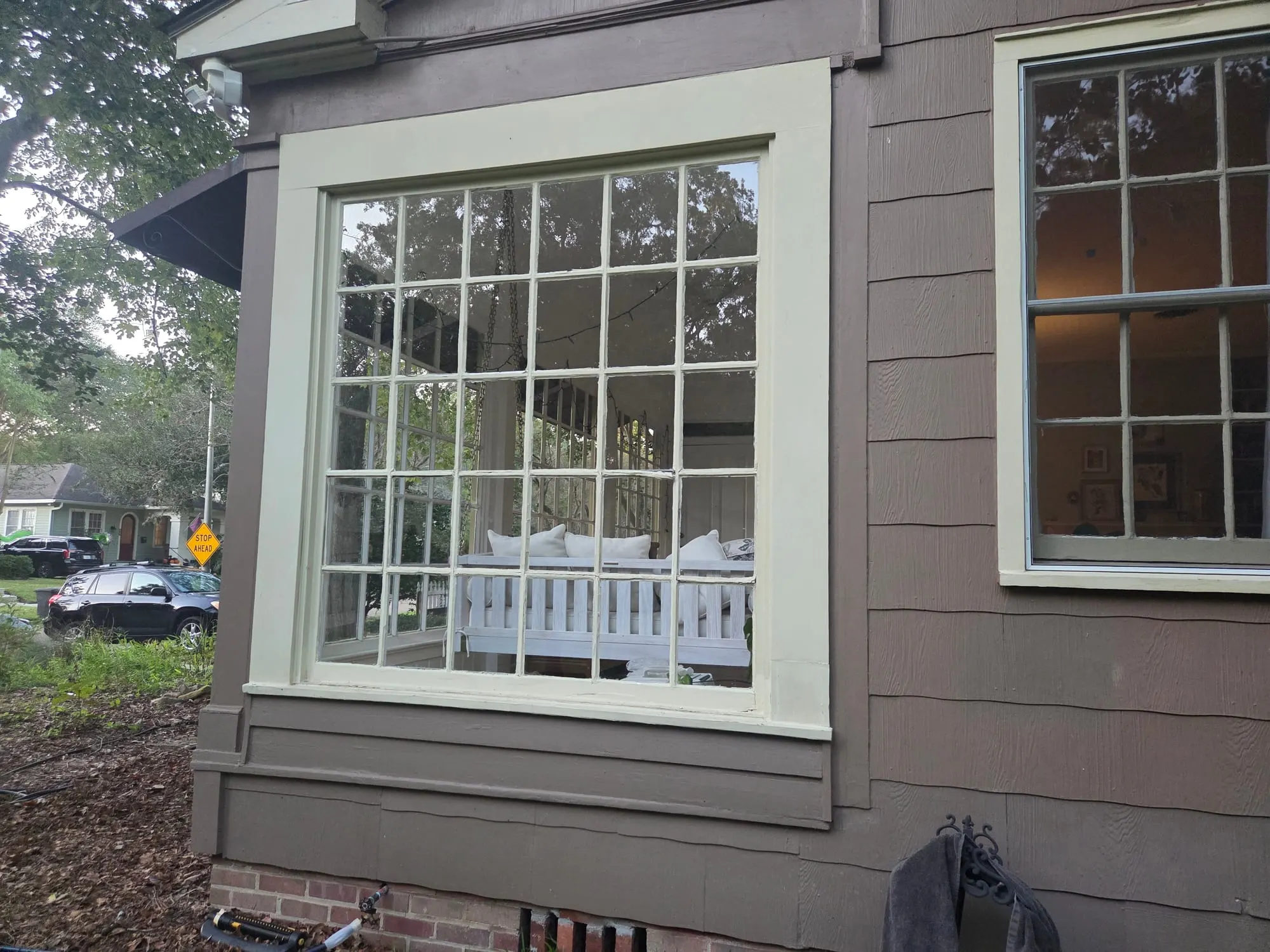 A large divided-light window with many small panes, clean and clear, on the side of a home
